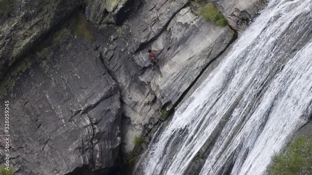 Man climbing down a beautiful epic waterfall Fisgas de Ermelo in Mondim de Basto, Portugal Man climbing down a beautiful epic waterfall Fisgas de Ermelo in Mondim de Basto, Portugal