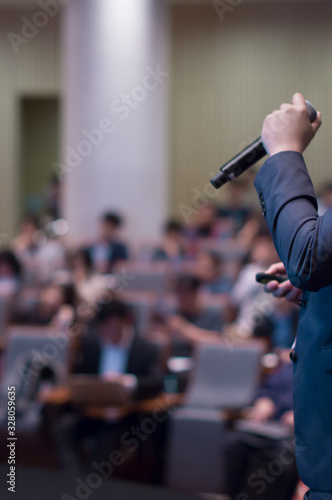 Speaker giving a talk at a corporate business conference. Audience photo in hall with presenter giving presentation in lecture. Corporate executive giving speech at business and entrepreneur seminar.