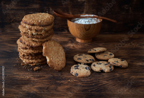 Oat cookies and flakes on a dark wooden table