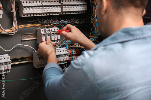 Male electrician repairing ...