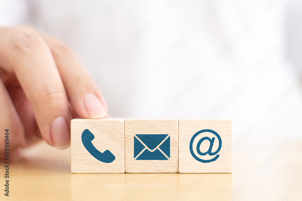 Businessman hand choose wooden block cube symbol icon telephone, envelope email and address sign. Website page contact us or e-mail marketing concept Businessman hand choose wooden block cube symbol icon telephone, envelope email and address sign. Website page contact us or e-mail marketing concept