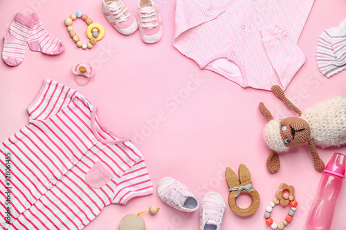 Frame made of baby clothes and accessories on color background