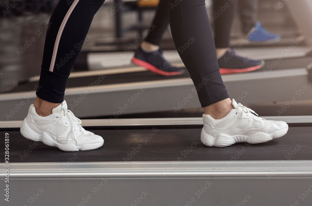 Cardio exercises. Unrecognizable woman on treadmill in gym, closeup