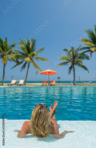 Beautiful woman relaxing in a pool at summer