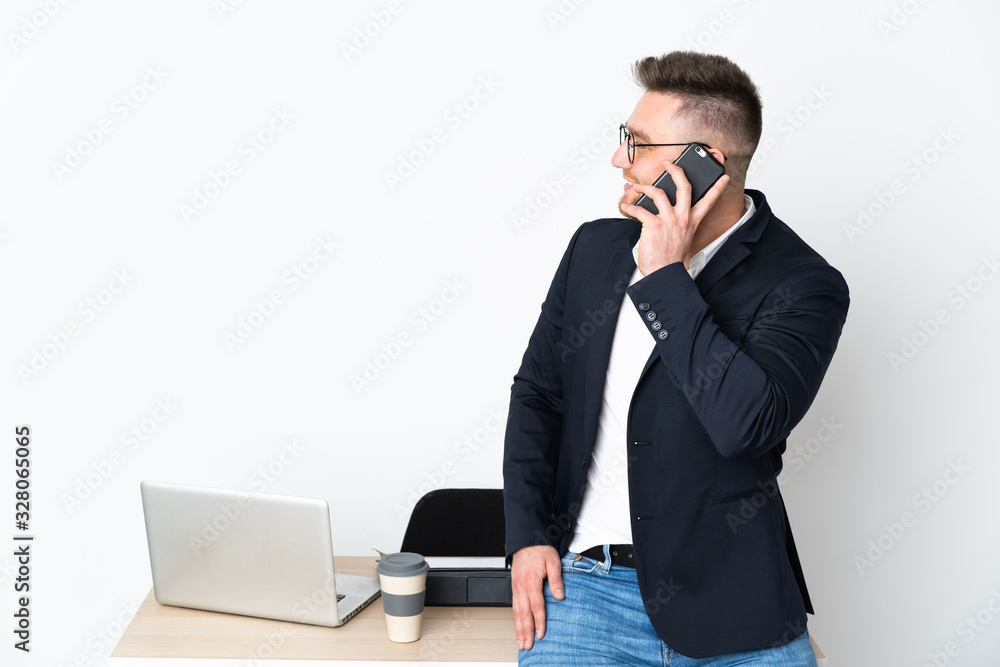 Russian man in a office isolated on white background keeping a conversation with the mobile phone with someone Russian man in a office isolated on white background keeping a conversation with the mobile phone with someone