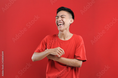 Portrait of happy young Asian man smiling in front of the camera