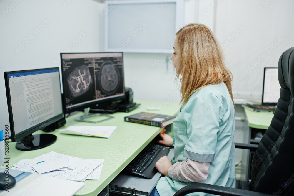 Medical theme. Doctor in the mri office at diagnostic center in hospital, sitting near monitors of computer. Medical theme. Doctor in the mri office at diagnostic center in hospital, sitting near monitors of computer.