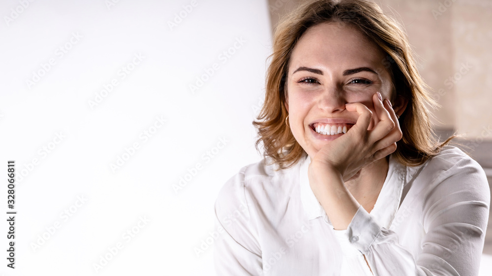 close-up portrait of a young happy smiling girl in a white shirt on a white background, copy space close-up portrait of a young happy smiling girl in a white shirt on a white background, copy space