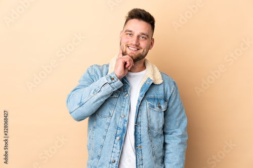 Russian handsome man over isolated background thinking an idea while looking up