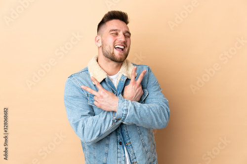 Russian handsome man over isolated background smiling and showing victory sign © luismolinero