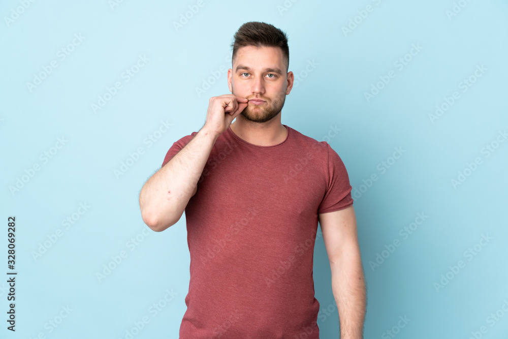 Russian handsome man over isolated background showing a sign of silence gesture Russian handsome man over isolated background showing a sign of silence gesture