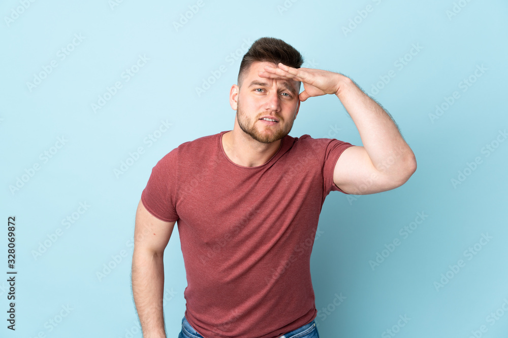 Russian handsome man over isolated background looking far away with hand to look something Russian handsome man over isolated background looking far away with hand to look something