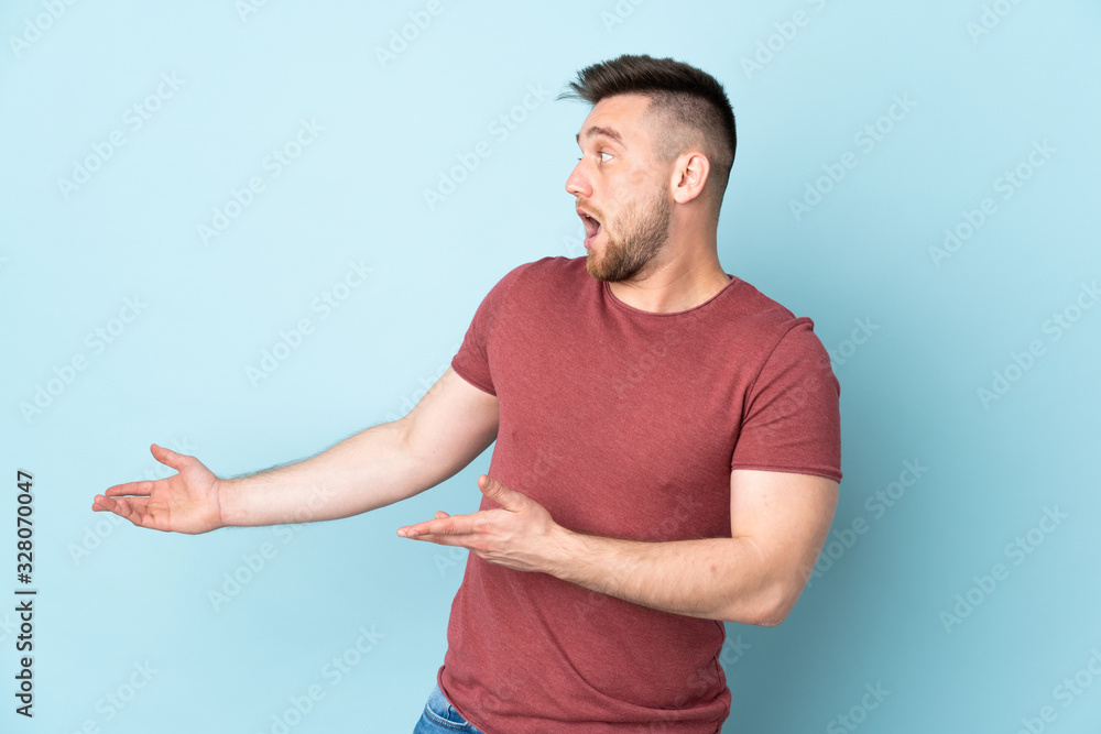 Russian handsome man over isolated background with surprise expression while looking side Russian handsome man over isolated background with surprise expression while looking side