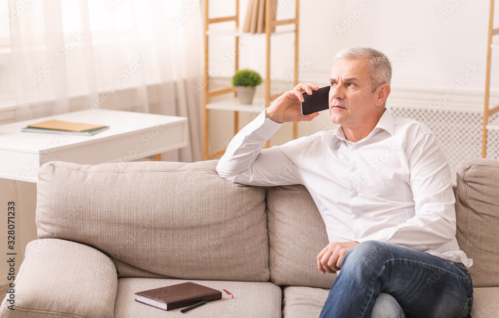Senior man talking on mobile phone at his home Senior man talking on mobile phone at his home