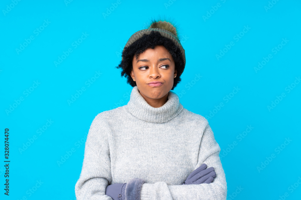 African american woman with winter hat over isolated blue background thinking an idea