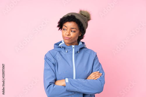 African american woman with winter hat over isolated pink background thinking an idea