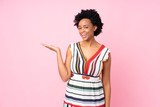 African american woman over isolated pink background presenting an idea while looking smiling towards