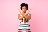 African american woman over isolated pink background making NO gesture