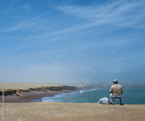 Man fishing at Paracas National park Peru. Desert and ocean. Coastal.