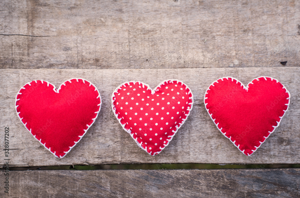 Three red heart shape on a wooden table Three red heart shape on a wooden table