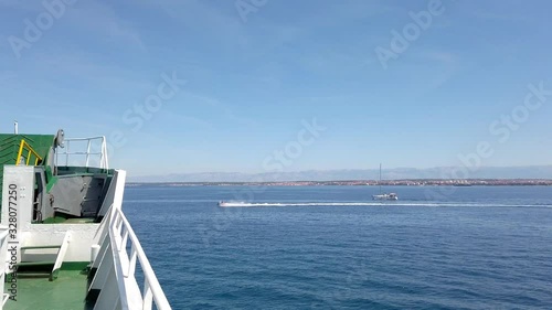 Ferry ship passing beside islands with boats and sailing boats in front. Filming beautiful adriatic surroundings while visiting Croatia.