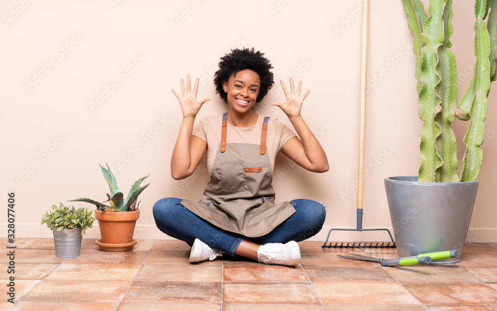 Gardener woman sitting on the floor counting ten with fingers Gardener woman sitting on the floor counting ten with fingers