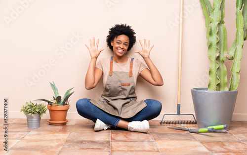 Gardener woman sitting on the floor counting ten with fingers