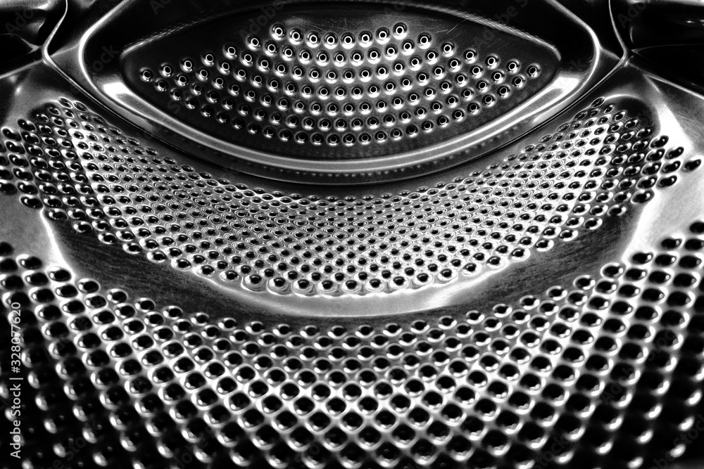 Washing machine drum interior. Perforated stainless steel drum for