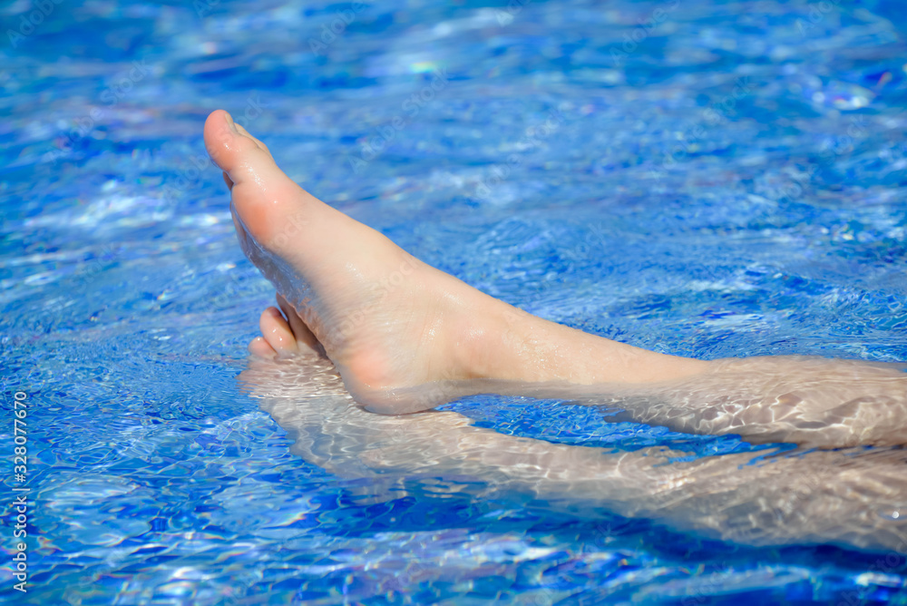 female feet in the outdoor pool
