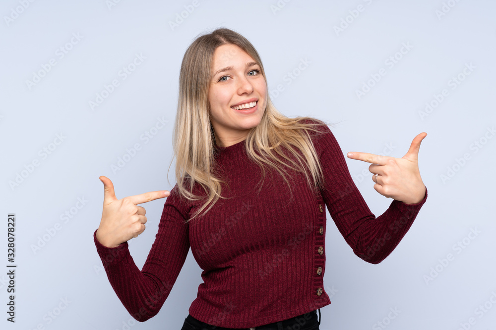 Young blonde woman over isolated blue background proud and self-satisfied Young blonde woman over isolated blue background proud and self-satisfied