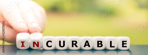 Hand turns dice and changes the word "incurable" to "curable".