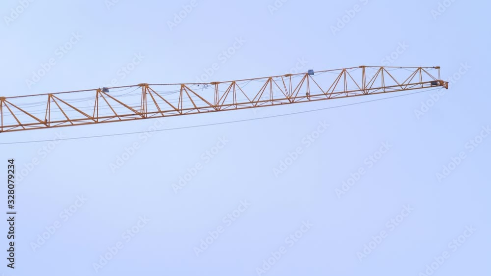 Electric crane in construction zone. From below of metal big crane on site against clear blue sky in modern city Electric crane in construction zone. From below of metal big crane on site against clear blue sky in modern city