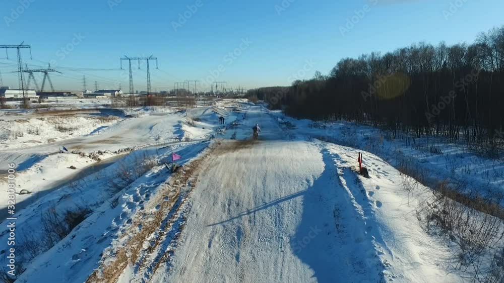 a motorcyclist performs stunts on a winter track a motorcyclist performs stunts on a winter track
