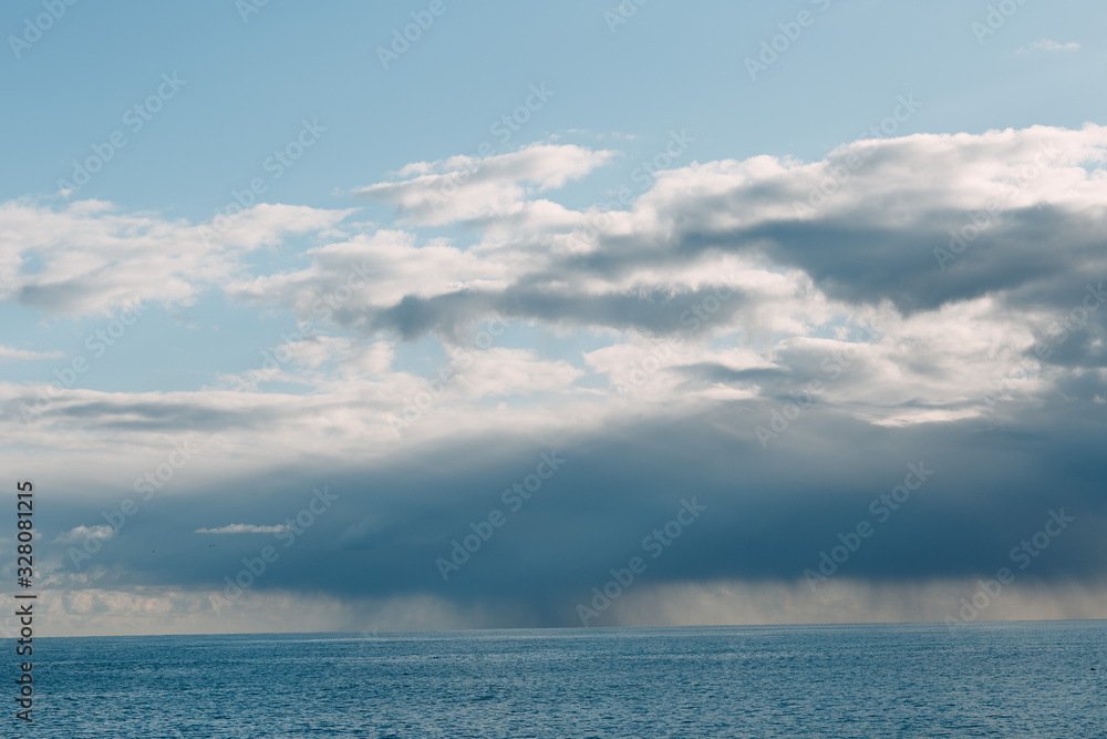 Thundercloud with rain on the sea horizon
