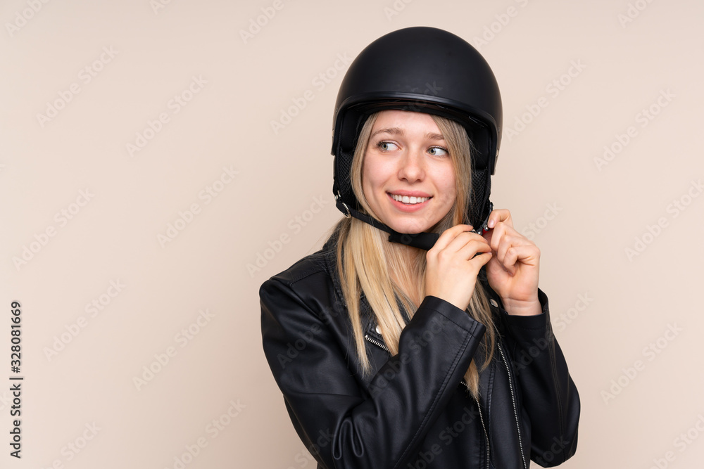 Young blonde woman with a motorcycle helmet over isolated background Young blonde woman with a motorcycle helmet over isolated background