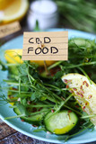 Selective focus. The inscription CBD food in a salad. Spring salad with microgreens, lemon and cucumber with seeds and the addition of CBD oil. CBD food concept. Super food.
