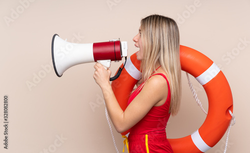 Lifeguard woman holding a megaphone over isolated background