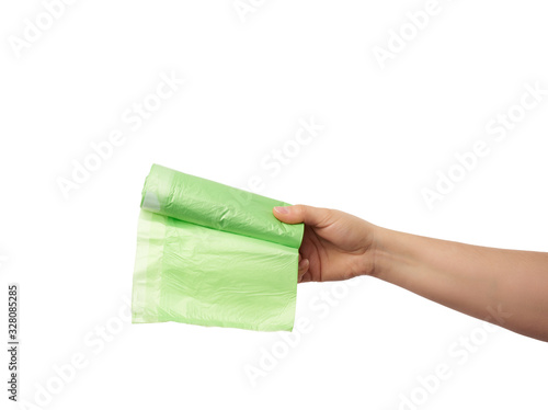 female hand holds a bundle of green plastic bags for garbage