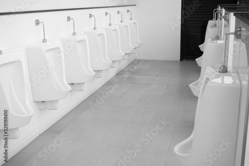 Black and white image concept, Male urinal room, Male toilet, Male toilets are not clean. Causing infection easily, White urine sanitary ware in a clean building for men. © singjai
