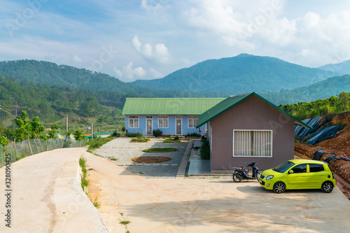 Transport near private houses in mountains and jungle in the background in tropics