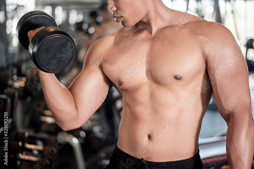 Close up muscular man is exercise in fitness gym