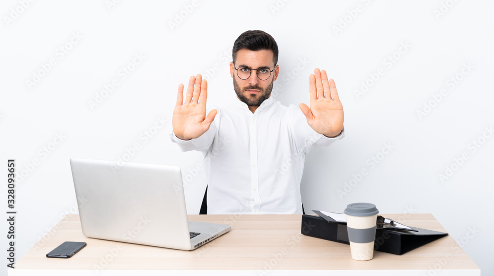 Young businessman in a workplace making stop gesture and disappointed Young businessman in a workplace making stop gesture and disappointed