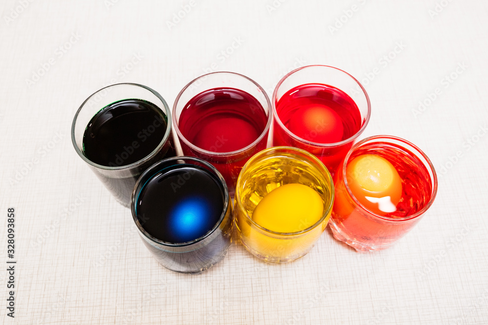 Painting process of Easter eggs by dye in the glasses. Home decorations for the holiday. Painting process of Easter eggs by dye in the glasses. Home decorations for the holiday.