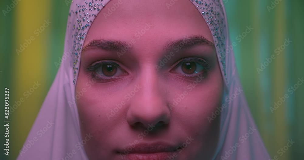 Close-up Beautiful confident girl in white hijab neon green glitter background Close-up Beautiful confident girl in white hijab neon green glitter background