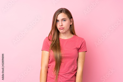 Teenager blonde girl over isolated pink background sad © luismolinero