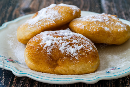 Mandazi is a slightly sweet East African Street Food; spicy, airy yeast doughnut dough made with coconut milk, flavored with cardamom and grated fresh coconut. photo