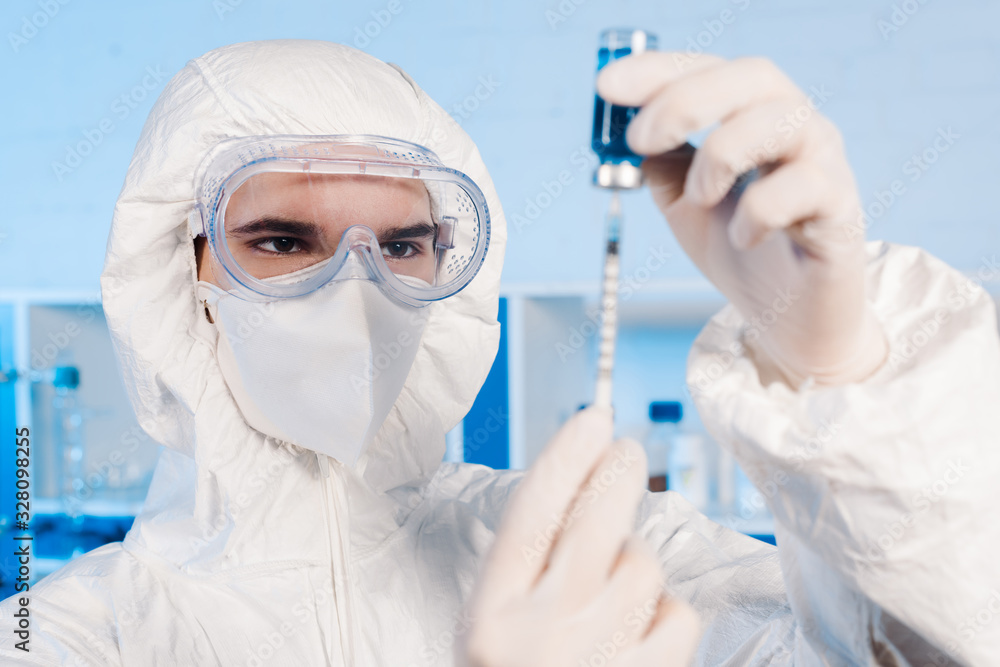 selective focus of scientist in latex gloves holding syringe and bottle with vaccine selective focus of scientist in latex gloves holding syringe and bottle with vaccine