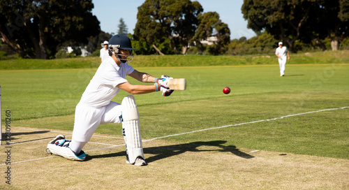 Cricket player shooting in the ball photo