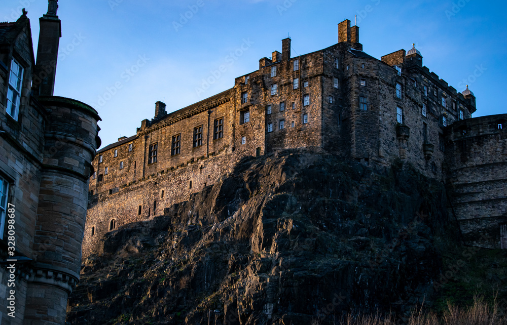 castle in edimburgh city, scotland on the rocks with a blue sky at sunset
