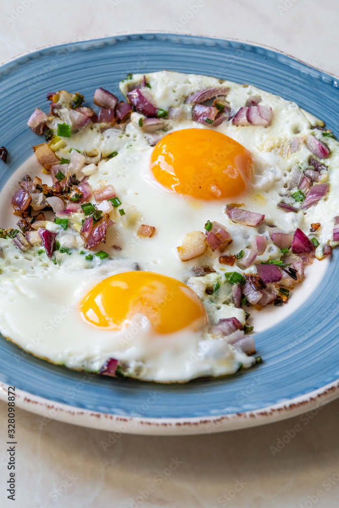 Sunny Side Up Fried Eggs with Red Onions and Chives for Breakfast in Plate. Sunny Side Up Fried Eggs with Red Onions and Chives for Breakfast in Plate.